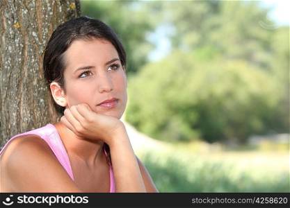 Pensive woman with tree trunk