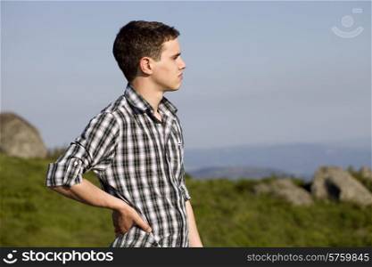 pensive young casual man at the top of the mountain