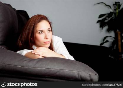 Pensive young girl relaxing on couch at home
