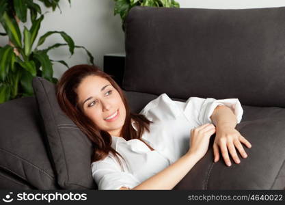 Pensive young girl relaxing on couch at home