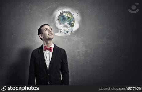 Pensive young man . Handsome young man in suit on concrete background looking up. Elements of this image are furnished by NASA