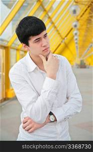 pensive young man on footbridge