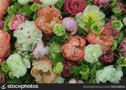 Peonies in various shades of pink and white in a floral wedding arrangement
