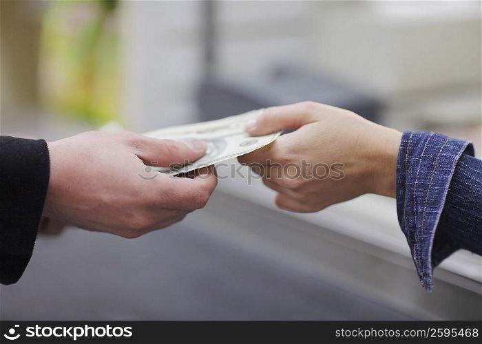 People&acute;s hands exchanging paper currency