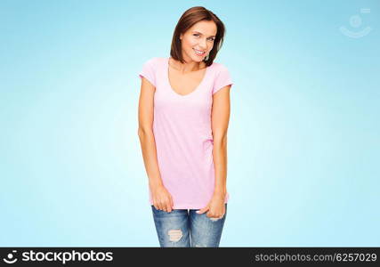 people, advertisement and clothing concept - happy woman in blank pink t-shirt over blue background