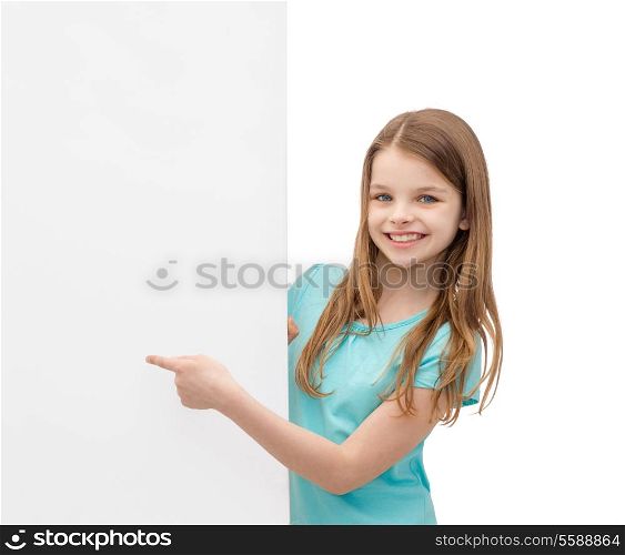 people, advertisement and sale concept - happy little girl pointing finger to blank white board