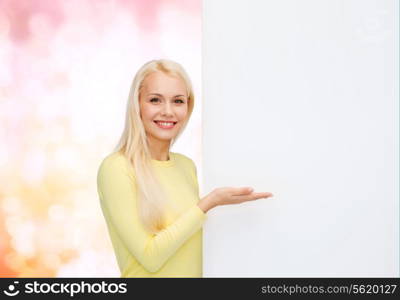 people, advertisement and sale concept - happy woman in sweater with blank white board
