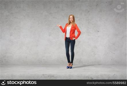 people, advertising and happiness concept - beautiful teenage girl in casual clothes on high heels holding something on her palm