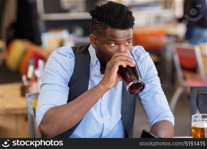 people and alcohol concept - man drinking draught beer at bar or pub. man drinking draught beer at bar or pub