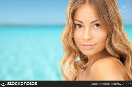 people and beauty concept - beautiful young woman over blue sky and sea background