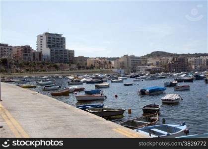 people and boats in the harbour of Bugibba on Malta