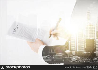 people and business concept - close up of businessman holding contract paper over city with double exposure. close up of businessman holding contract paper