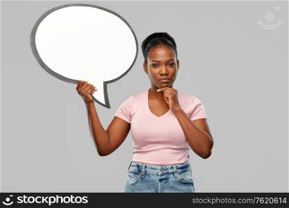 people and communication concept - african american young woman holding big blank speech bubble over grey background. african american woman holding speech bubble