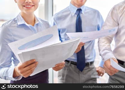 people and corporate concept - close up of happy business team with papers meeting at office. happy business team with papers meeting at office