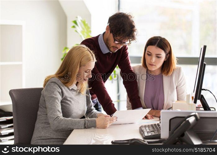 people and corporate concept - happy business team with papers meeting in office. happy business team with papers in office