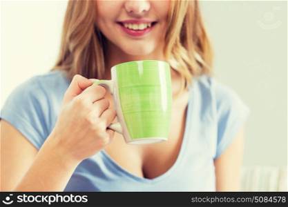 people and drinks concept - close up of happy woman or teen girl drinking tea from cup. happy woman or teen girl drinking tea from cup. happy woman or teen girl drinking tea from cup