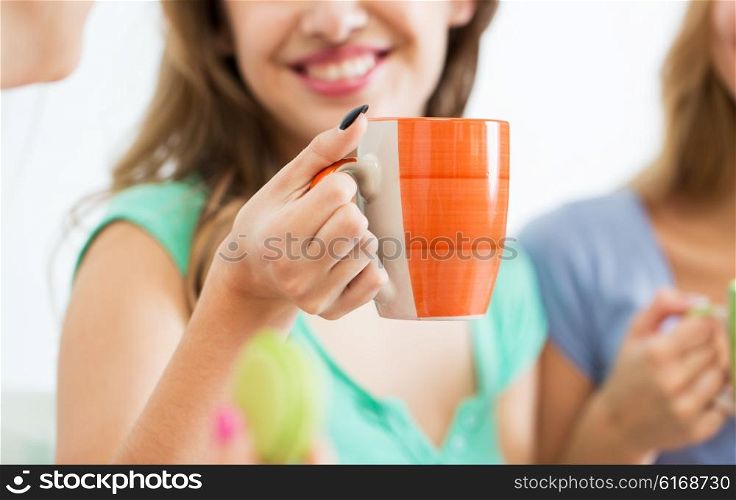 people and drinks concept - close up of happy woman or teen girl drinking tea from cup. happy woman or teen girl drinking tea from cup
