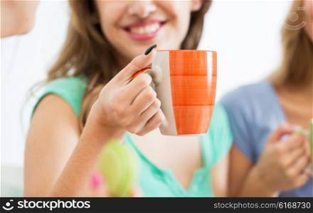 people and drinks concept - close up of happy woman or teen girl drinking tea from cup. happy woman or teen girl drinking tea from cup