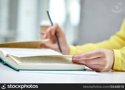 people and education concept - close up of female hands to book or textbook at school. close up of female hands to book or textbook