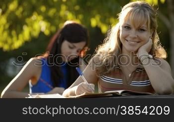 People and education, two young women studying with book for university test in park. Sequence