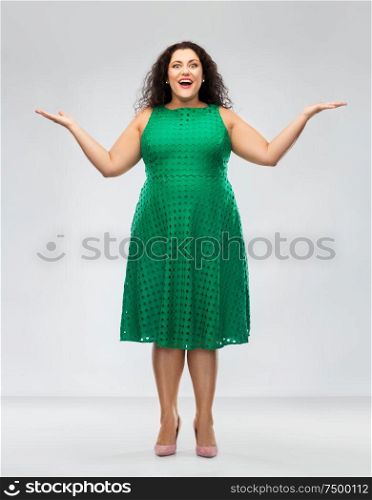 people and emotion concept - happy amazed woman in green dress over grey background. happy smiling woman in green dress
