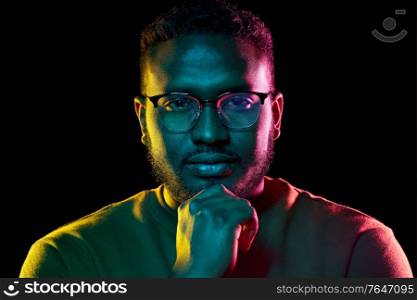 people and ethnicity concept - portrait of young african american man in glasses over black background. young african american man in glasses over black