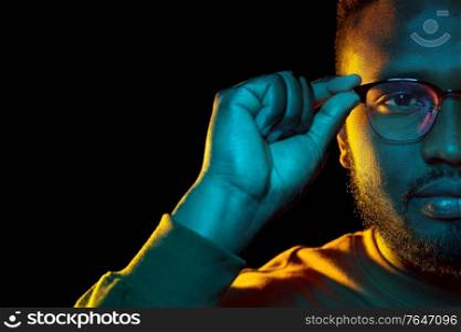 people and ethnicity concept - portrait of young african american man in glasses over black background. young african american man in glasses over black