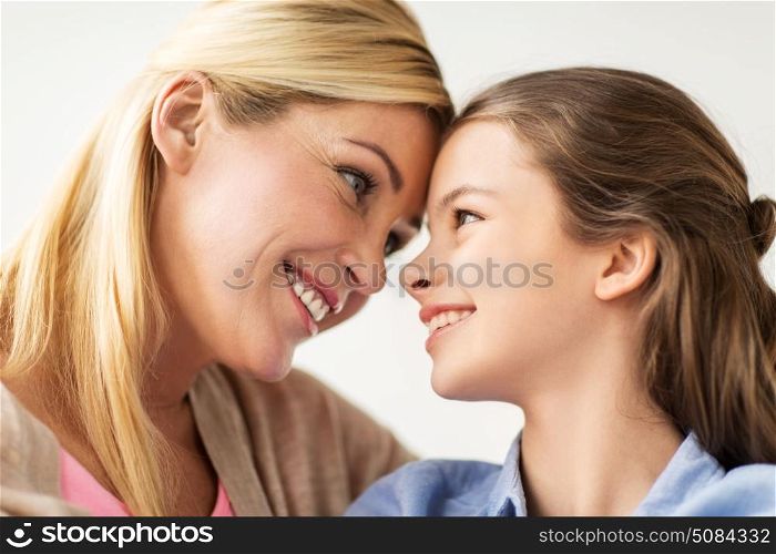 people and family concept - happy smiling girl with mother at home. happy smiling family of girl and mother at home. happy smiling family of girl and mother at home
