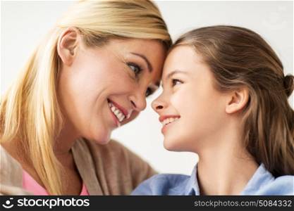people and family concept - happy smiling girl with mother at home. happy smiling family of girl and mother at home. happy smiling family of girl and mother at home