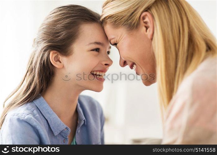 people and family concept - happy smiling girl with mother at home. happy smiling family of girl and mother at home