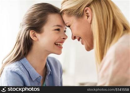 people and family concept - happy smiling girl with mother at home. happy smiling family of girl and mother at home