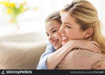 people and family concept - happy smiling girl with mother at home. happy smiling family hugging at home