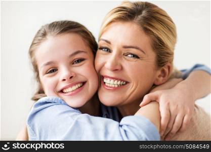 people and family concept - happy smiling girl with mother hugging. happy smiling family hugging. happy smiling family hugging