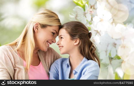 people and family concept - happy smiling mother and daughter over cherry blossom background. happy mother and daughter over cherry blossom. happy mother and daughter over cherry blossom