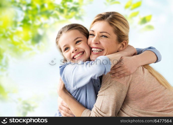 people and family concept - happy smiling mother hugging daughter over green natural background. happy smiling mother hugging daughter. happy smiling mother hugging daughter