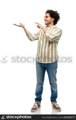 people and fashion concept - happy smiling man in glasses holding and showing something imaginary on his hand over white background. happy man in glasses holding something imaginary