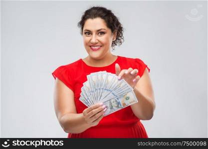people and finances concept - happy woman in red dress holding hundreds of dollar money banknotes over grey background. happy woman holding hundreds of money banknotes