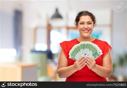 people and finances concept - happy woman in red dress holding hundreds of euro money banknotes over office background. happy woman holding hundreds of money banknotes