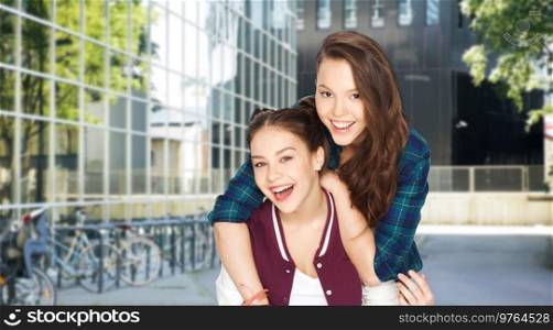 people and friendship concept - happy smiling pretty teenage girls having fun over city street or school yard background. happy teenage girls having fun in city