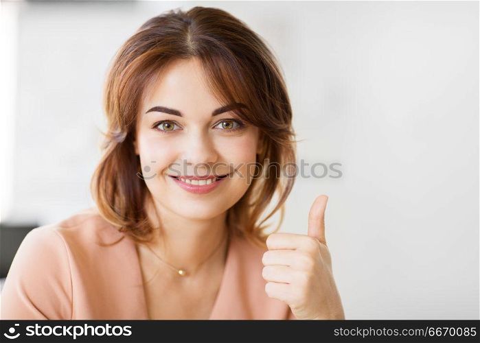 people and gesture concept - portrait of happy smiling young woman showing thumbs up. portrait of smiling young woman showing thumbs up. portrait of smiling young woman showing thumbs up