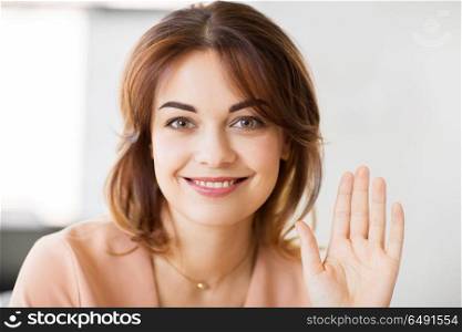 people and gesture concept - portrait of happy smiling young woman waving hand. portrait of smiling young woman waving hand. portrait of smiling young woman waving hand
