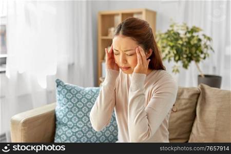 people and health concept - sick asian woman having headache at home. sick asian woman having headache at home