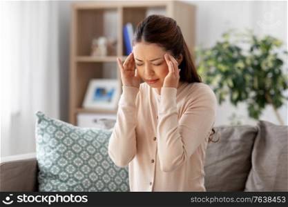 people and health problem concept - sick asian woman having headache at home. sick asian woman having headache at home