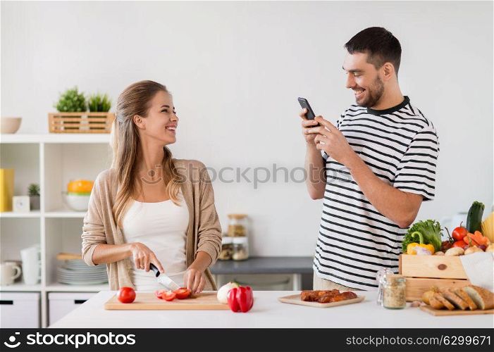 people and healthy eating concept - happy couple cooking food at home kitchen. happy couple cooking food at home kitchen