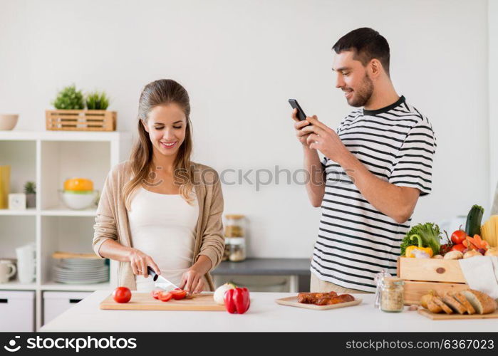 people and healthy eating concept - happy couple cooking food at home kitchen. happy couple cooking food at home kitchen