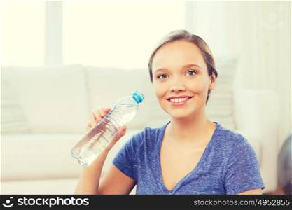 people and healthy lifestyle concept - happy woman with bottle of water at home. happy woman with water bottle at home