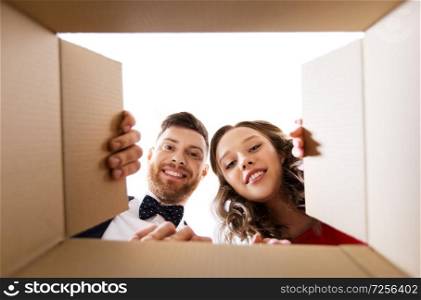 people and holidays concept - happy couple opening christmas gift box. happy couple opening christmas gift box