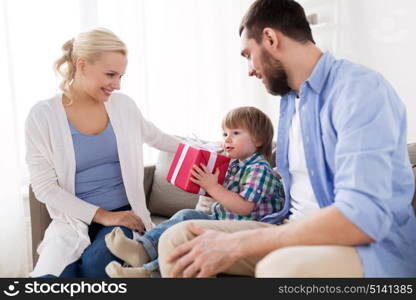 people and holidays concept - happy family with birthday gift at home. happy family with birthday gift at home