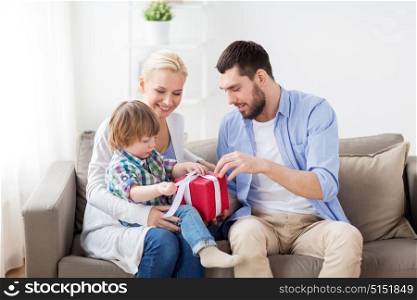 people and holidays concept - happy family with birthday gift at home. happy family with birthday gift at home