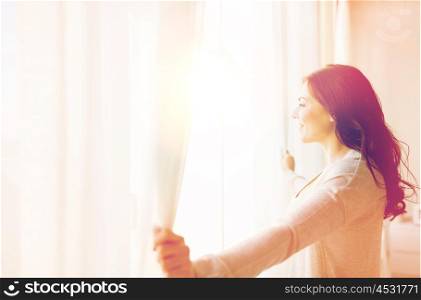 people and hope concept - close up of happy woman opening window curtains. close up of woman opening window curtains